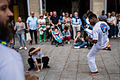 Mitglieder der Mestre Branco Capoeira Escola demonstrieren auf der Straße während der Fiestas von El Pilar in Zaragoza, Aragonien, Spanien