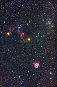 Eine Rahmung einiger Sternhaufen und Nebel im westlichen Zwilling und nördlichen Orion, aufgenommen in einer teilweise dunstigen Nacht, in der die Farben der Sterne durch Glühen hervorgehoben werden.