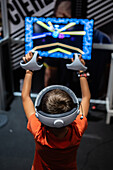 Junger Junge spielt mit Meta Quest 2 All-in-One VR-Headset während ZGamer, einem Festival für Videospiele, digitale Unterhaltung, Brettspiele und YouTuber während der El Pilar Fiestas in Zaragoza, Aragon, Spanien