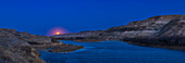 Der aufgehende Vollmond vom 5. Mai 2023 über dem Red Deer River in der Nähe von East Coulee, Alberta. Dies ist ein Panorama der Badlands-Szene, wobei der Standort mit der App The Photographer's Ephemeris geplant wurde.