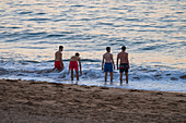 Kids on Grande Plage beach at sunset in Saint Jean de Luz,fishing town at the mouth of the Nivelle river,in southwest France’s Basque country