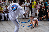 Mitglieder der Mestre Branco Capoeira Escola demonstrieren auf der Straße während der Fiestas de El Pilar in Zaragoza, Aragonien, Spanien