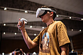 Teenager spielt mit Meta Quest 2 All-in-One VR-Headset während ZGamer, einem Festival für Videospiele, digitale Unterhaltung, Brettspiele und YouTuber während der El Pilar Fiestas in Zaragoza, Aragonien, Spanien