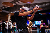 Junger Mann spielt mit Meta Quest 2 All-in-One-VR-Headset während ZGamer, einem Festival für Videospiele, digitale Unterhaltung, Brettspiele und YouTuber während der El Pilar Fiestas in Zaragoza, Aragonien, Spanien