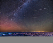 This is the Perseid meteor shower over the badlands of Dinosaur Provincial Park,in the Red Deer River valley in Alberta,with the summer sky above filled with about two dozen meteors from the annual shower on August 12,2023. The meteors all appear to be streaking away from the radiant point in Perseus at left,below the "W" of Cassiopeia. The meteor trails are shortest near the radiant point,as at that location they are coming at us head on. The Andromeda Galaxy is near centre.