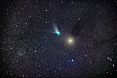 Comet C/2022 E3 (ZTF) passing Mars in the constellation of Taurus on the night of Feb 10,2023. Mars appears to be at the tip of a dark lane of interstellar dust in the Taurus Dark Clouds. The comet is showing its whitish dust tail and blue ion tail,as well as its cyan coma from diatomic carbon emission. The star cluster at left is NGC 1746.