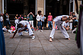 Mitglieder der Mestre Branco Capoeira Escola demonstrieren auf der Straße während der Fiestas de El Pilar in Zaragoza, Aragonien, Spanien