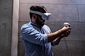 Young man playing with Meta Quest 2 all-in-one VR headset during ZGamer,a festival of video games,digital entertainment,board games and YouTubers during El Pilar Fiestas in Zaragoza,Aragon,Spain