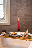 Badewannenablage mit Kerze, Snacks und Weihnachtsdeko im Badezimmer