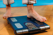 Woman using body composition scales