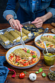 Fish fillet with herb crust on tomato pasta