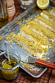 Fish fillet with herb crust on baking tray