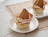 Shortcrust pastry baskets with robiola and raw ham