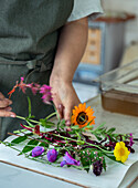 Frau arbeitet mit frisch geschnittenen Wildblumen