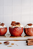Baked apples with nut filling, garnished with cream and maple syrup