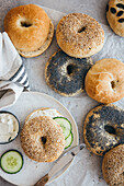 Sesame and poppy seed bagels topped with cream cheese and cucumber