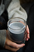 Activated charcoal latte in hands