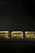 Sandwiches mit Erbsencreme vor schwarzem Hintergrund