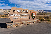 Entrance sign to Dinosaur National Monument with Split Mountain behind, near Jensen, Utah.