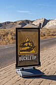 A traffic sign at the entrance to Dinosaur National Monument saying, "Don't Join the Fossils. Buckle Up."