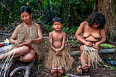 Women knitting clothes Yagua Indians living a traditional life near the Amazonian city of Iquitos, Peru.