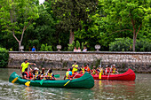 Young people practicing canoeing on rio Tajo river or Tagus river in the La Isla garden Aranjuez Spain.