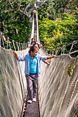 Elevated canopy walk hanging bridges. A rain forest canopy walkway in the Amazon forest tambopata national park, at the Inkaterra amazonica reserve. Visitors have a birds eye view from the Amazon jungle canopy walkway at river napo camp Explorama tours in Peru. Iquitos, Loreto, Peru. The Amazon Canopy Walkway, one of the longest suspension bridges in the world, which will allow the primary forest animals from a height of 37 meters and is suspended over the 14 tallest trees in the area.