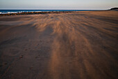 Wind weht Sand an einem Strand in Lanzarote, Kanarische Inseln, Spanien