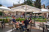 Restaurants Bar tables and tourists dining in Plaza de San Diego square in front of the university of Alcala de Henares Madrid Spain