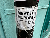 Meat is murder sticker on street sign