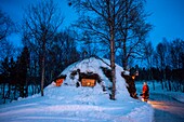 Samische Frau und ihr Haus in Lønsdal Storjord, Norwegen. Saltfjellet-Svartisen-Nationalpark