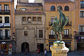 The statue of Juan Bravo and the Renaissance palaces of Medina del Campo square in the city center of Segovia.