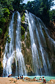 Touristen an der malerischen Kaskade des Wasserfalls El Limon im Dschungel der Halbinsel Samana in der Dominikanischen Republik. Erstaunlicher Sommerblick des Wasserfalls im tropischen Wald