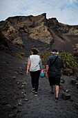 Volcan del Cuervo (Krähenvulkan), ein Krater, der über einen Rundweg in einer kargen, felsigen Landschaft erkundet wird