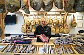 France, Hautes Pyrenees, Beaucens, portrait of Pierre Sajous, artisan pork butcher specializing in Black Pig of Bigorre and game, holding in his hands a piece of black pork chop from Bigorre