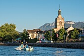Frankreich, Haute Savoie, Evian les Bains, ein Berufsfischer in einem Boot, nimmt die Netze von feras in der Nähe des Ufers des Sees Leman, die Kirche und die Felsen der Memises