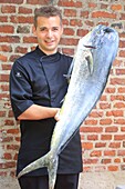 France, Nord, Wambrechies, restaurant Le Balsamique, its chef (Benjamin Bajeux) with a dolphinfish (Coryphaena hippurus)