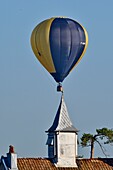 Frankreich, Doubs, Brognard, Heißluftballon fliegt über den Kirchturm der Dorfschule