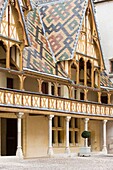 France, Cote d'Or, Burgundy climates listed as World Heritage by UNESCO, Beaune, Hospices de Beaune, Hotel Dieu, roof in varnished tiles multicolored in courtyard, Hospices de Beaune, compulsory mention
