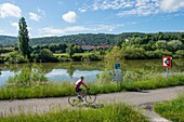 France, Doubs, Baumes Les Dames, veloroute, euro bike 6, a cyclist on the route in front of the village of Vaire and the river Doubs