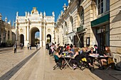 Frankreich, Meurthe et Moselle, Nancy, Stanislas-Platz (ehemaliger königlicher Platz), erbaut von Stanislas Leszczynski, König von Polen und letzter Herzog von Lothringen im 18. Jahrhundert, von der UNESCO zum Weltkulturerbe erklärt, Bogen Here (Here-Bogen), gekrönt von Skulpturen mit dem Namen Groupe de la Renommee, Glockenturm der Basilika Saint Epvre und Cafés