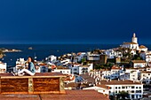 Spanien, Katalonien, Girona, Cadaques, Blick auf ein Dorf am Meer unter einem stürmischen Himmel am späten Nachmittag