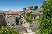 Frankreich, Aveyron, La Couvertoirade, beschriftet mit Les Plus Beaux Villages de France (Die schönsten Dörfer Frankreichs), dominanter Blick auf einen Dorfkern mit einem Steinkreuz im Vordergrund