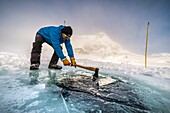 France, Isère (38), Belledonne, Chamrousse, Robert Lakes, while a team of divers is preparing to dive under the ice, the director of the Dive Xtreme club prepares the skylights by breaking the cool ice of the night