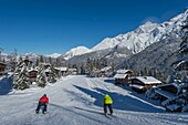 Frankreich, Haute Savoie, Massiv des Mont Blanc, die Contamines Montjoie, die kurze Skimethode auf den Skipisten, 2 Skifahrer in Schussposition inmitten von Chalets