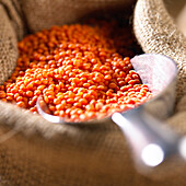 Red lentils in a linen sack with a scoop