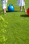 Children with skippy ball on lawn