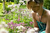 Woman looking at Astrantia flowers