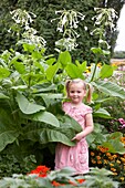 Girl beside nicotiana plant