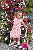 Girl in front of large petunia container